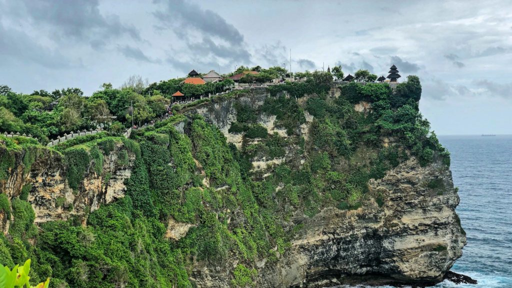 green and brown mountain beside body of water during daytime
